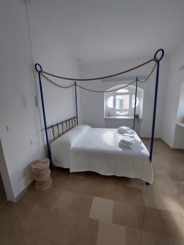 una camera bianca con letto a baldacchino. di Palazzo Accinni B&B a Monopoli