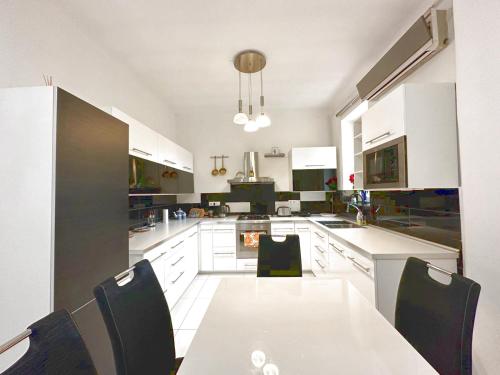 a large white kitchen with a table and chairs at Penthouse in the castle in Budapest
