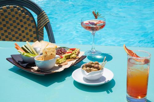 a table with a plate of food and a drink at Cormoran Residence in Villasimius