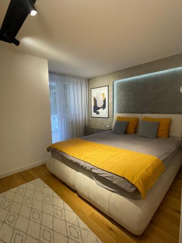 a bedroom with a large bed with yellow sheets at Golden Apartment With King Bed in Sarajevo