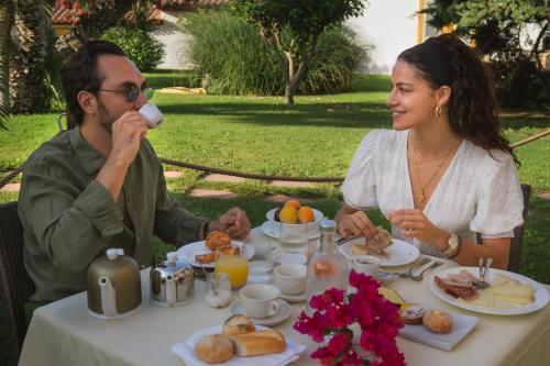 a man and woman sitting at a table eating breakfast at Cormoran Residence in Villasimius