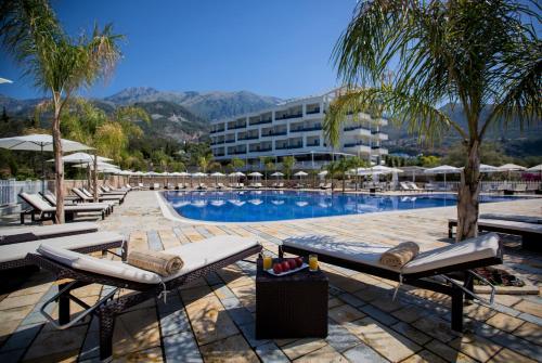 a swimming pool with lounge chairs and a hotel at Elysium Hotel in Dhërmi