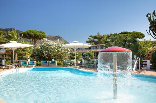 a swimming pool with a fountain in the middle at Cormoran Residence in Villasimius