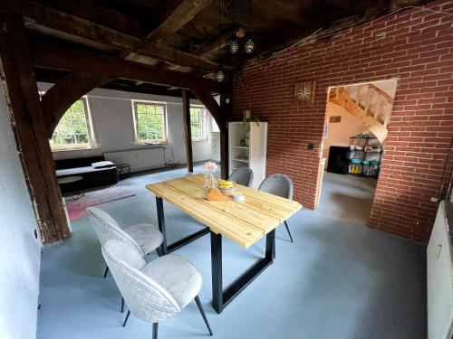 uma sala de jantar com uma mesa de madeira e cadeiras em Fachwerkhaus in Alfhausen 