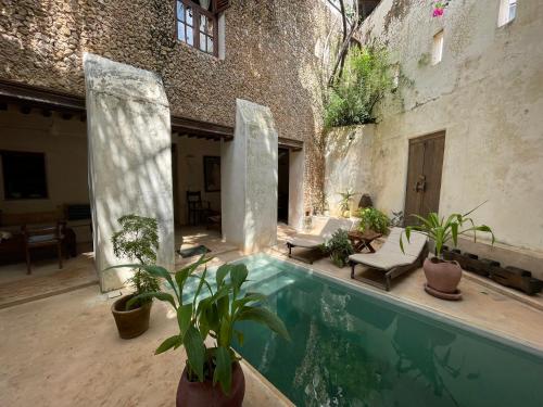 a courtyard with a swimming pool in a building at Authentic Swahili style villa Milele House in Lamu