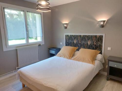 ein Schlafzimmer mit einem großen weißen Bett und zwei Fenstern in der Unterkunft Appartement en Rez-de-jardin in Autrans