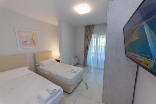 une chambre avec deux lits et une télévision à écran plat dans l'établissement Luxury Villa 4, à Vlorë