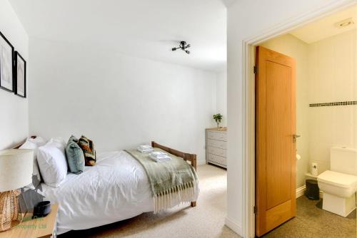 um quarto branco com uma cama e uma casa de banho em Bright 1 bed central Worthing with sofa bed sleeps up to 4 close to beach by Eagle Owl Property em Worthing