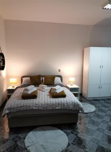a bedroom with a large bed with two tables and two lamps at Lucija in Gospić