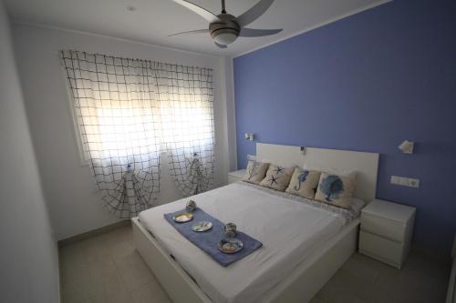 um quarto azul com uma cama com dois pratos em Trilocale moderno e centrale a Los Cristianos em Los Cristianos
