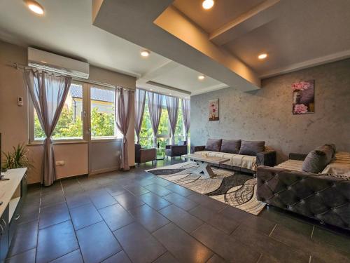 uma sala de estar com um sofá e uma mesa em Lux Apartman Lazarević em Bajina Bašta