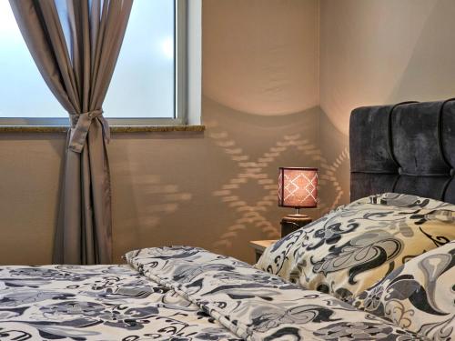 a bedroom with a bed and a window and a lamp at Lux Apartman Lazarević in Bajina Bašta