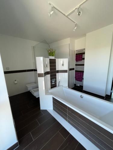 a bathroom with a white tub and a mirror at Villa WanderLux in Zella-Mehlis
