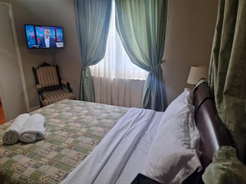 a bedroom with a bed with a television and a window at Valia's house -Makri Village in Mákri