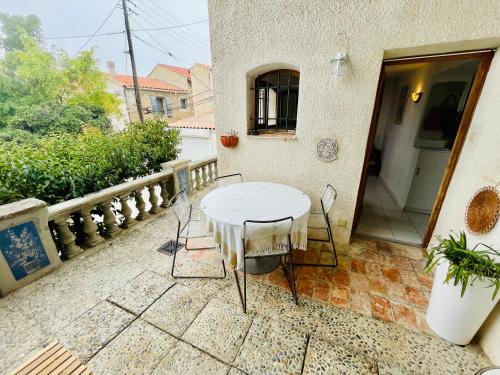 - Balcón con mesa blanca y sillas en Appartement duplex avec terrasse vue mer en Marsella