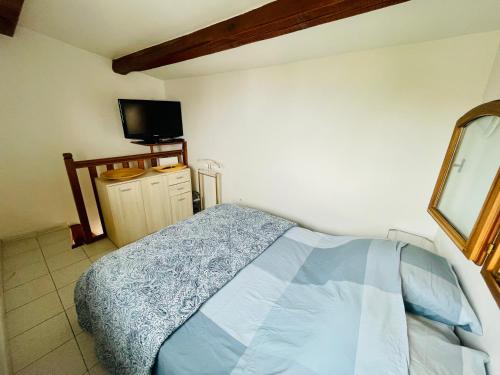1 dormitorio con 1 cama y TV de pantalla plana en Appartement duplex avec terrasse vue mer en Marsella