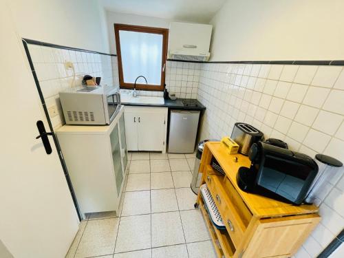 una pequeña cocina con fregadero y microondas en Appartement duplex avec terrasse vue mer en Marsella