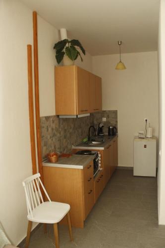 a small kitchen with a white chair and a white refrigerator at Zeusplace Anastasia's Apartment 2 in Litochoro