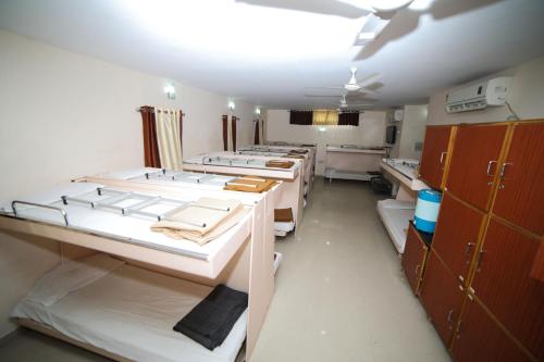 a room with a row of bunk beds in it at Hotel Vrundavan Residency in Vadodara