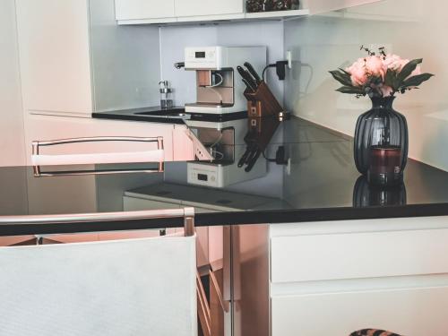 a kitchen with a vase with flowers on a counter at Wasserfall - Zentrum - Balkon - Seeblick - Küche in St. Moritz