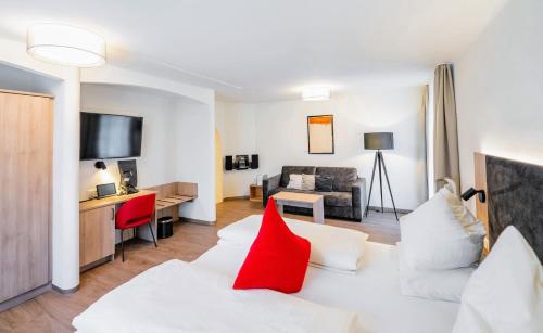 فندق روزنفيلا في سالزبورغ: غرفة معيشة مع أريكة بيضاء ووسائد حمراء