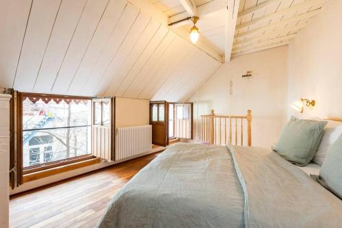 sypialnia z dużym łóżkiem i dużym oknem w obiekcie Carriage House in quiet ecological garden w Antwerpii