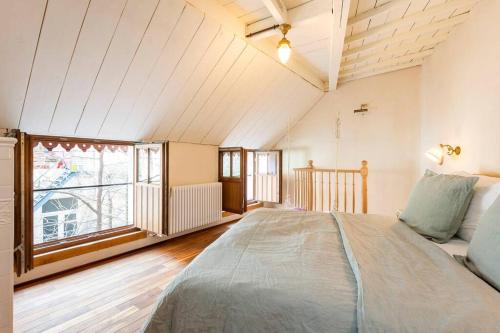 a bedroom with a large bed and a large window at Carriage House in quiet ecological garden in Antwerp