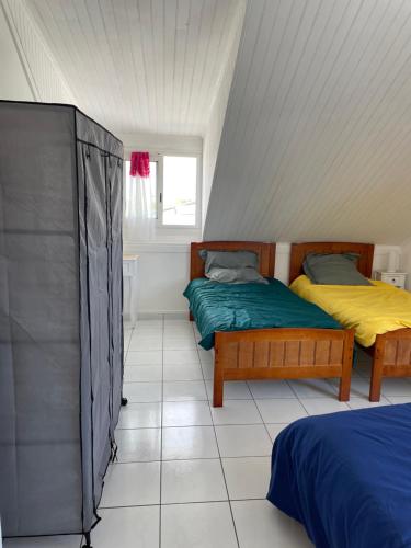 um quarto com 2 camas e uma janela em ti sable appartement à 5 minutes de la mer em Saint-Joseph