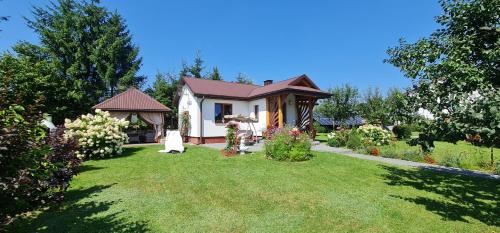 a small house in a yard with a garden at Domek na wsi z Jacuzzi in Jedle
