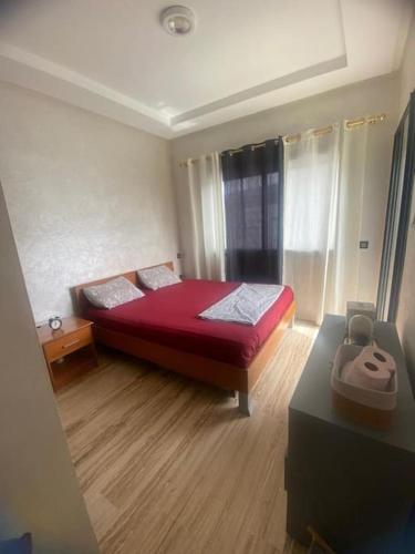een slaapkamer met een rood bed in een kamer bij Élégant & Cosy Appartement in Casablanca