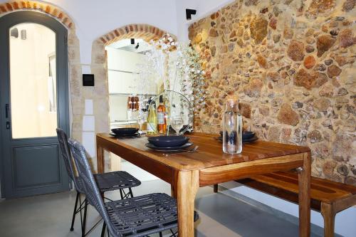 una sala da pranzo con tavolo in legno e parete in pietra di Porto 57 a Chania