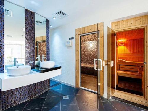 a bathroom with two sinks and a shower at 3 bedroom marina beach view apartment skyview tower marina in Dubai