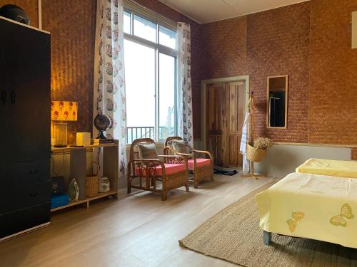 - une chambre avec un lit et une grande fenêtre dans l'établissement Casablanca Homestay, à Aizawl