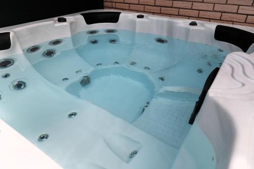 a jacuzzi tub with blue water in it at Goldhouse - Sauna, Whirlpool, Switch, Darts & mehr in Andernach