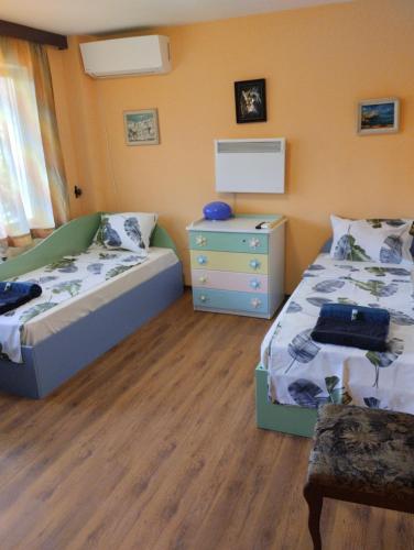 a bedroom with two twin beds and a dresser at Гери2 in Arbanasi