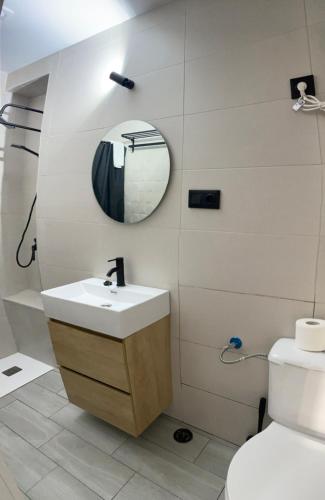 a bathroom with a sink and a mirror and a toilet at Estudios Barbate Playa 4 in Barbate