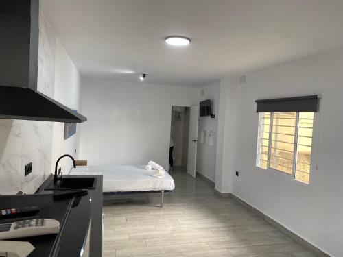 a white room with a bed and a window at Estudios Barbate Playa 4 in Barbate