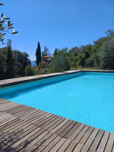 a large blue swimming pool with a wooden deck at Villa Al Ponte in Case Malva