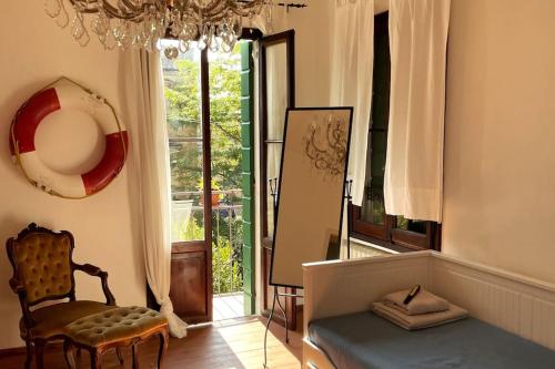uma sala de estar com um sofá, uma cadeira e uma janela em Venezia Lido Villa Delle Palme em Lido di Venezia