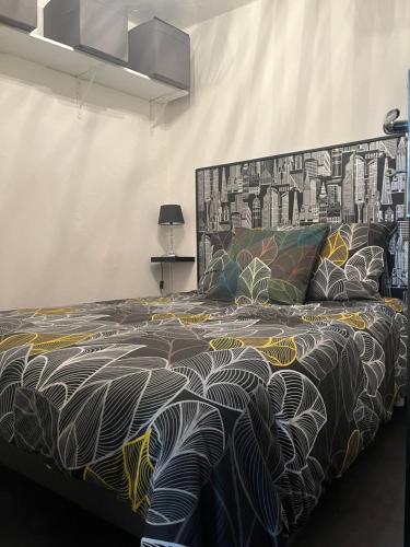 a bedroom with a bed with a black and white blanket at Le central in Barcelonnette