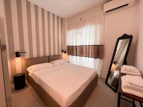 Dormitorio pequeño con cama y espejo en Casetta Celso, en Roma