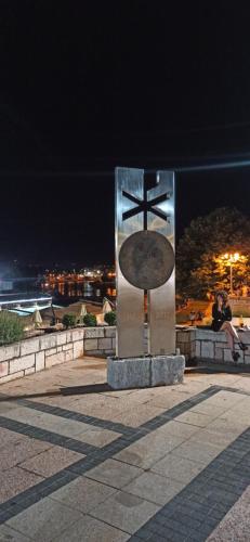 a statue of a cross with a person sitting on a wall at Lux apartment 10 center, free parking in Niš
