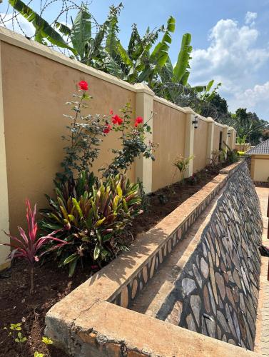 a retaining wall with flowers next to a fence at Makanga Hill Suites in Kabale
