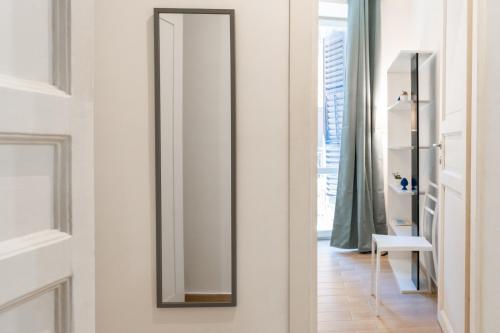 ein Spiegel hängt an einer Wand in einem Zimmer in der Unterkunft Four Luxury Apartment in Palermo