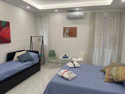 Un dormitorio con dos camas y una mesa y sillas. en B&B Dietro al Duomo, en Salerno