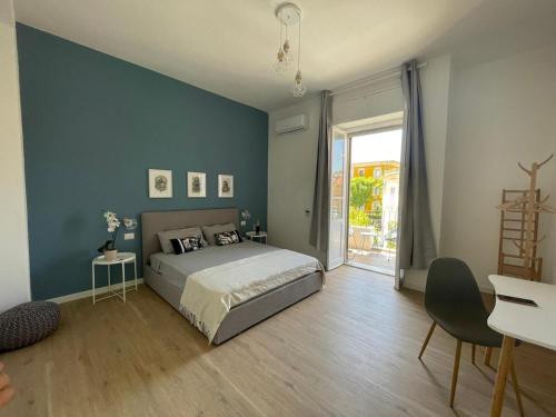 sypialnia z łóżkiem i niebieską ścianą w obiekcie Sunset 221 Cagliari w Cagliari
