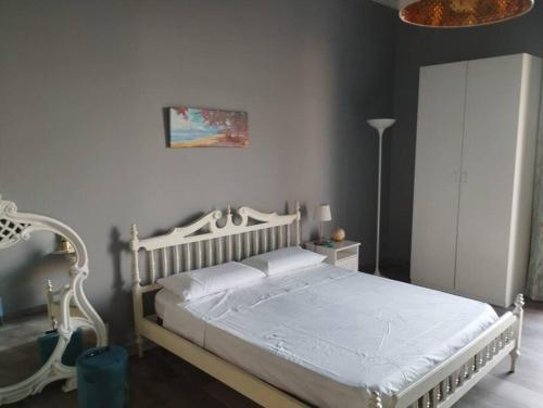 um quarto com uma cama branca num quarto em Benedettini House em Catânia