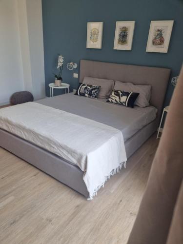 a large bed in a bedroom with blue walls at Sunset 221 Cagliari in Cagliari