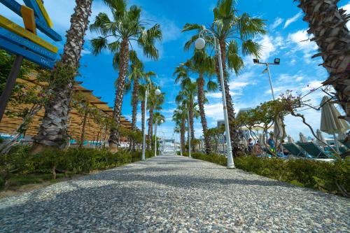 a sidewalk lined with palm trees on a beach at Granada Luxury Belek - Family Kids Concept in Belek