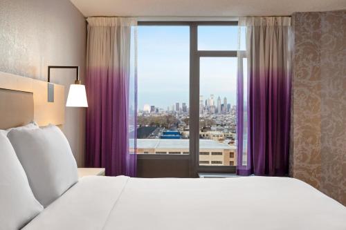 1 dormitorio con cama grande y ventana grande en Holiday Inn Philadelphia Arpt-Stadium Area, an IHG Hotel, en Filadelfia